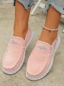 Close-up detail of stylish pink canvas slip-on shoes with trendy frayed edges for women