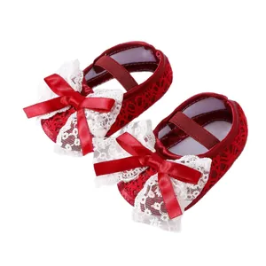 Red newborn baby shoes with white lace and satin bows for special occasions
