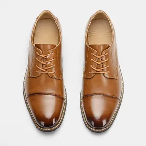 Detailed top-down view of classic men's brown cap-toe leather business shoes on white background
