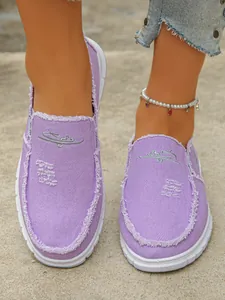 Close-up detail of stylish purple distressed canvas slip-on shoes for women on-foot