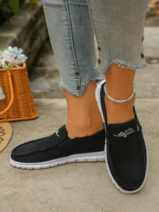 Women's black canvas slip-on loafers with frayed edges and pearl anklet detail