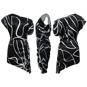 Vue sous trois angles d'une mini-robe noire asymétrique à imprimé abstrait blanc