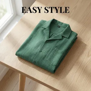 Vista detallada de una camisa verde de hombre con cuello cubano en una mesa de madera