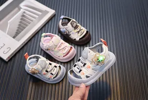 Close-up detail of the LED light-up cartoon bear feature on white toddler sandals
