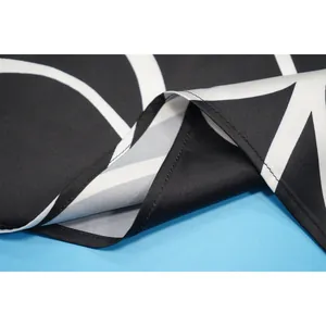 Gros plan sur le tissu rayé noir et blanc et les coutures fines d'une robe de mode élégante.