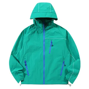Giacca leggera unisex con protezione UV verde acqua e cerniere blu a contrasto con cappuccio.
