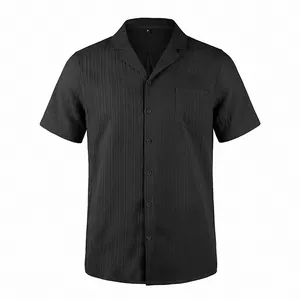 Primer plano de camisa negra con cuello cubano, textura de ondas y bolsillo frontal