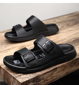 Détail des sandales noires à double boucle pour hommes sur fond de bois rustique