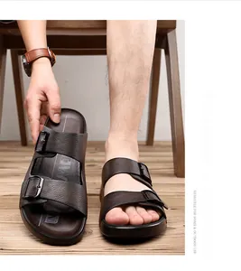 Vue détaillée de sandales marron pour hommes en similicuir à double boucle sur bois.