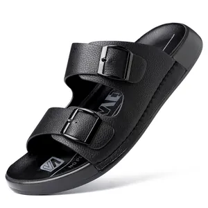Gros plan de claquettes noires pour hommes avec doubles boucles et finition texturée.