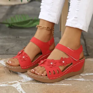 Detailansicht der roten Damen-Keilsandalen mit floralen Akzenten und verstellbaren Riemen.