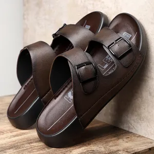 Gros plan détaillé de sandales en cuir marron pour hommes avec doubles boucles noires