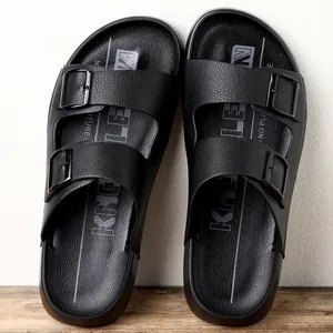 Vue détaillée de sandales noires pour hommes avec deux brides, boucles et texture cuir