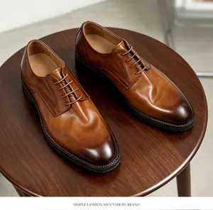Vista detallada superior de zapatos oxford de cuero marrón sobre madera