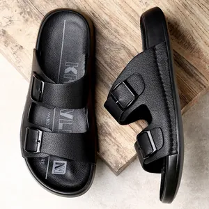 Vue détaillée de mules noires à double boucle pour hommes sur une planche en bois rustique.
