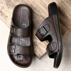Gros plan sur des mules en cuir marron pour hommes avec doubles boucles noires