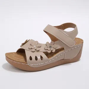 Detailansicht beige Keilsandaletten mit Blumen-Applikationen, Strass und Klettverschluss.