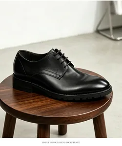 Vista detallada de los zapatos de negocios en cuero negro sobre un taburete de madera.