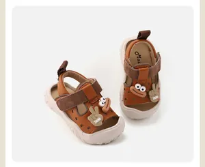 Gros plan de sandales pour tout-petits en marron avec semelles souples et breloques amusantes