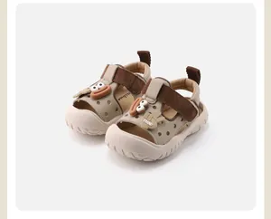 Gros plan de sandales pour bébés fermées avec motif dessin animé en beige.