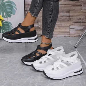 Macro view of black and white platform wedge sandals featuring Roman style velcro straps.