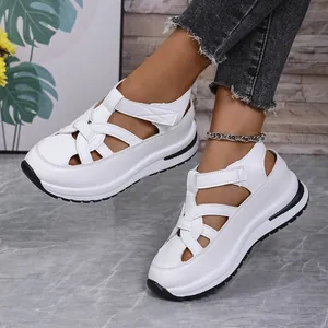 Close-up of white platform wedge sandals with velcro straps and cut-out design