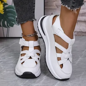 Close-up of white Roman-style wedge platform sandals with Velcro straps on a model.