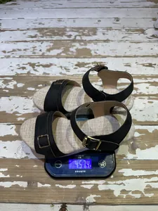 Detailed view of women's wedge sandals being weighed, showing 457.4g on a digital scale.