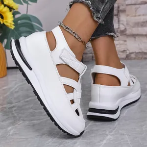 Stylish white platform sandals featuring Roman style cut-outs and adjustable velcro straps