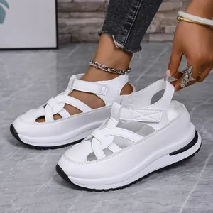 Detail view of white wedge platform sandals with woven straps and velcro closure.