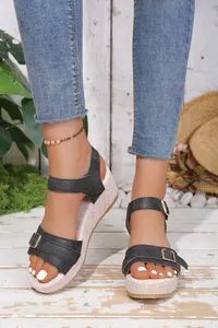 Stylish black wedge platform sandals with buckle straps shown on model feet