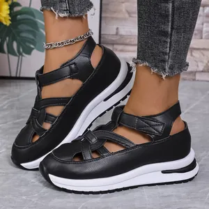 Side view detail of black platform wedge sandals with velcro straps and a thick white sole
