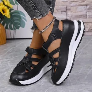 Close-up of black platform sandals with hook and loop straps on model's feet