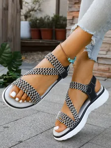 Nahaufnahme von geflochtenen Damen-Sandalen in einem rustikalen Außengarten-Ambiente