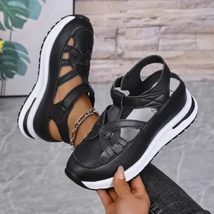 Detailed view of black Roman-style platform sandals with velcro straps and thick white soles.