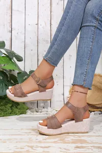 Detailed view of women's brown buckle strap wedge sandals with a textured platform