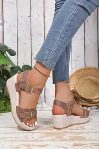 Detailed view of women's brown wedge platform sandals with adjustable buckle straps