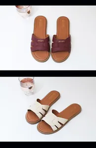 Viste dettagliate di eleganti ciabatte piatte con cinturini incrociati in bordeaux e crema