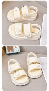 Detailansicht von stilvollen cremefarbenen Mädchen-Sandalen mit dicker Sohle und Herz-Details