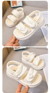 Detailansicht weißer Mädchen-Plateausandalen mit herzförmigen Schnallenornamenten