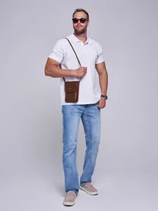 Caucasian male model wearing blue straight-leg loose denim jeans in a studio setting