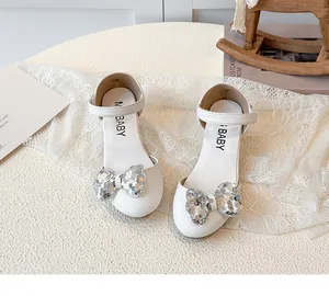 Dettaglio scarpe da principessa bianche per bambina con fiocco di paillettes