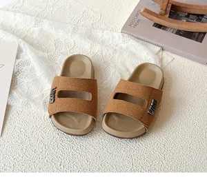 Detailed macro view of children's brown suede forest style sandals with metal accents