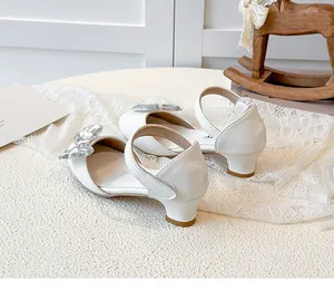 Vista posteriore di scarpe con tacco da principessa bianche con fiocchi di paillettes