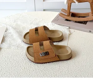 Tan brown children's suede Birkenstock-style slides featuring decorative metal logo