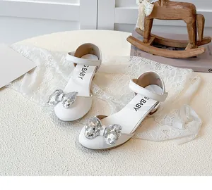 Dettaglio scarpe da principessa bianche per bambine con fiocco di paillettes argento