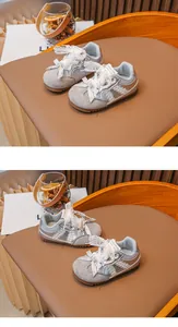 Vue détaillée des baskets argentées pour filles avec nœuds en dentelle sur une chaise en bois