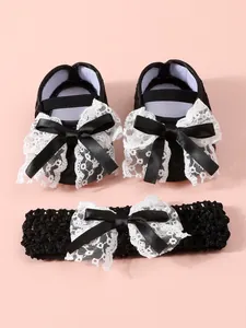 High-quality detail of newborn baby set with black lace shoes and bow headband