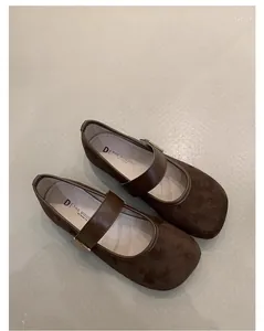 Detalle de vista superior de elegantes zapatos planos Mary Jane en gamuza marrón con correa