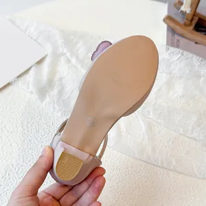 Sandali da principessa rosa con fiocco per bambine che mostrano la suola delle scarpe